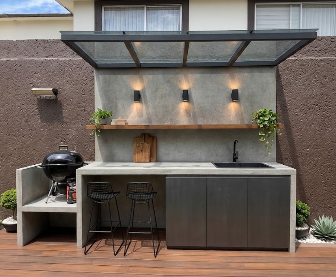 Jardín residencial con terraza y área de asador